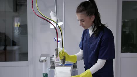 woman at work in laundry shop with handheld cleaning tool