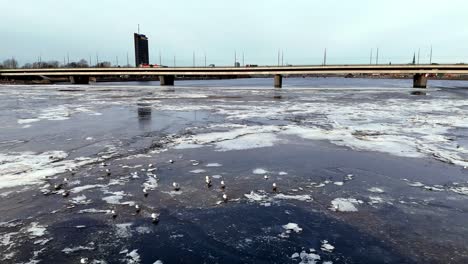 a bridge over a frozen river with a large building in the background