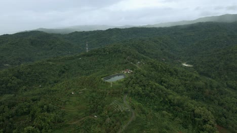 Vista-Aérea-Del-Depósito-De-Agua-En-Medio-Del-Bosque-De-Colinas