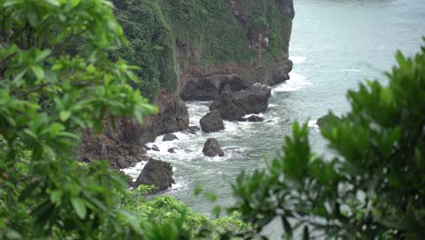 las olas rompiendo contra las rocas en la costa del mar del sur de java