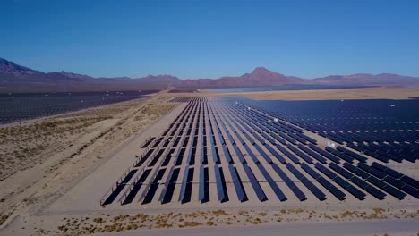 aerial side view of solar farm near desert mountains