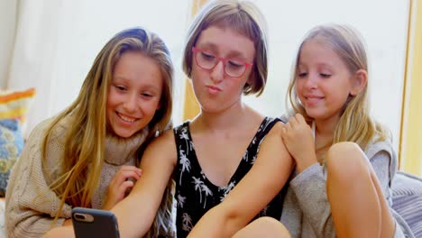 siblings taking selfie with mobile phone in living room 4k