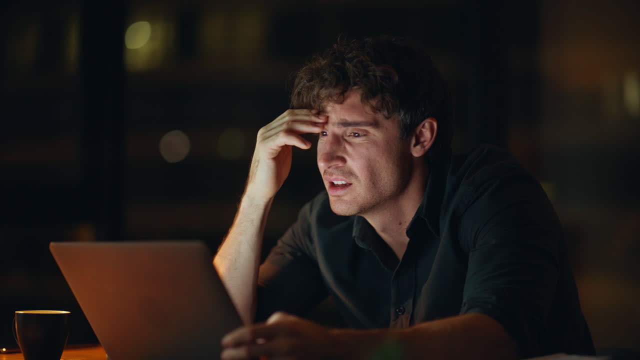 Depressed employee frustrated job problem at night office closeup. Desperate man