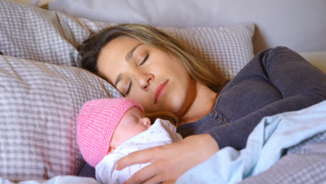 mother sleeping with her baby boy in bedroom 4k