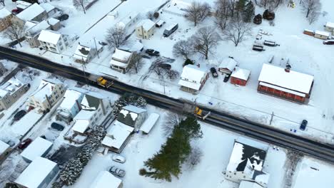 Dos-Camiones-Quitanieves-Con-Cuchillas-Y-Sal-Circulando-Por-La-Carretera-A-Través-De-La-Ciudad-De-EE.UU.-Cubierto-De-Nieve-Del-Invierno