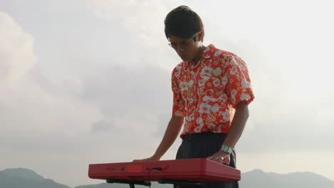 Slow-motion-of-a-man-playing-the-piano-outside-with-wind