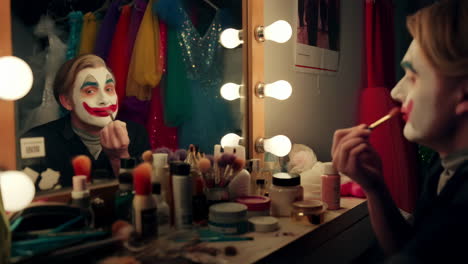 person applying clown makeup in a dressing room