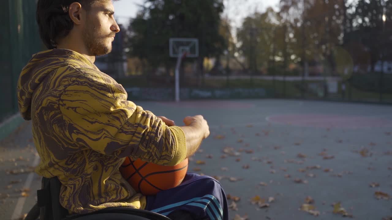 un joven en silla de ruedas en la cancha de baloncesto. cámara lenta.