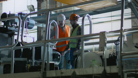 ingenieros de fábrica inspeccionando la maquinaria