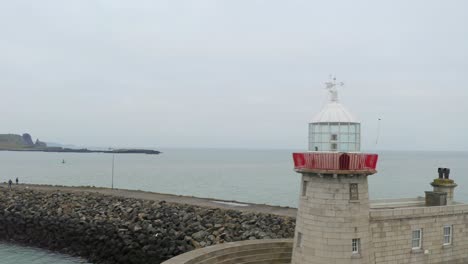 aerial dynamic shot captures howth lighthouse, ending with a close-up of the lantern