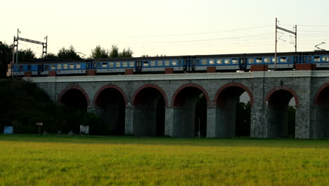Railway-viaduct-with-a-passing-passenger-train-crossing-the-bridge