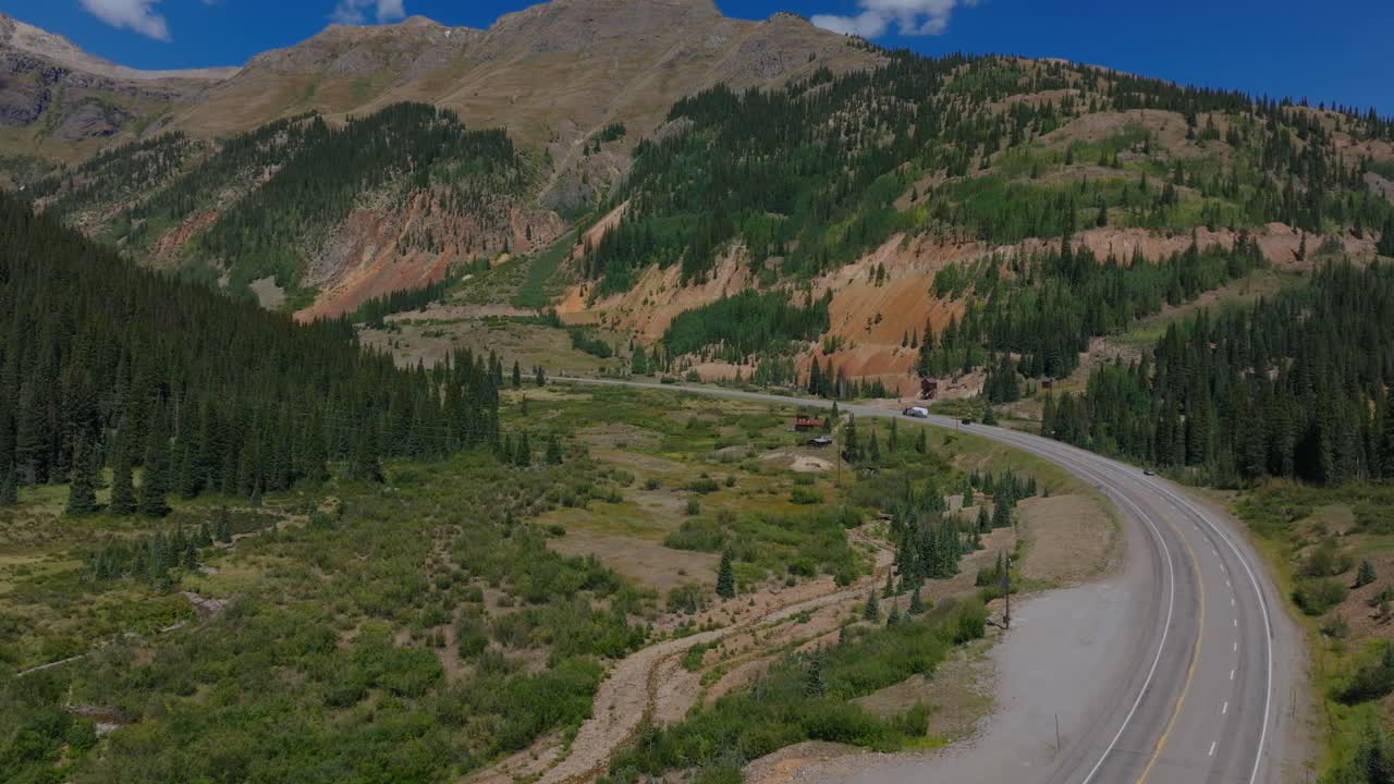 Strada di montagna tortuosa che attraversa il terreno accidentato del Colorado sotto cieli estivi sereni, Million Dollar Highway Colorado USA.