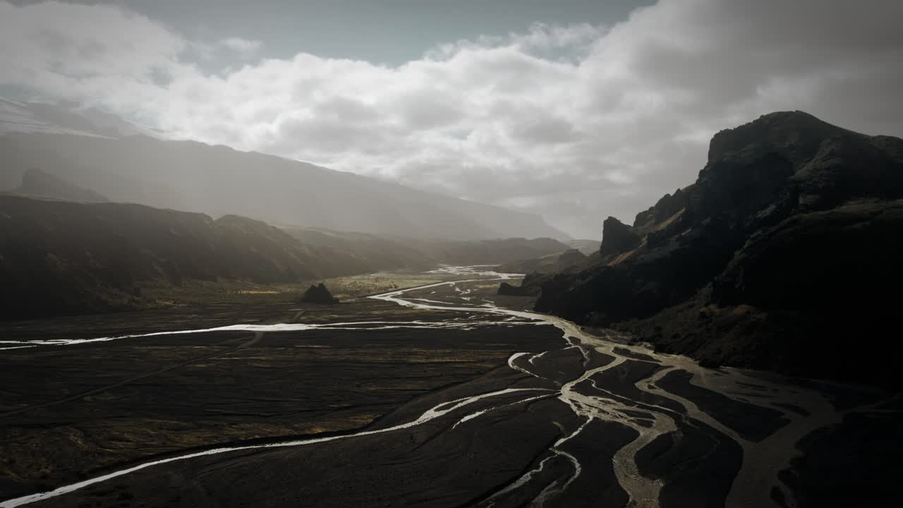 Cinematic aerial thor valley, glacial river flowing through black volcanic scenery bridges for river crossings, thorsm&ouml;rk Iceland