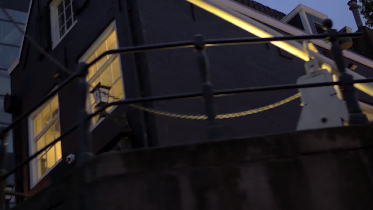 암스테르담 네덜란드의 조명 창문이 있는 건물의 강 배를 이동하는 모습