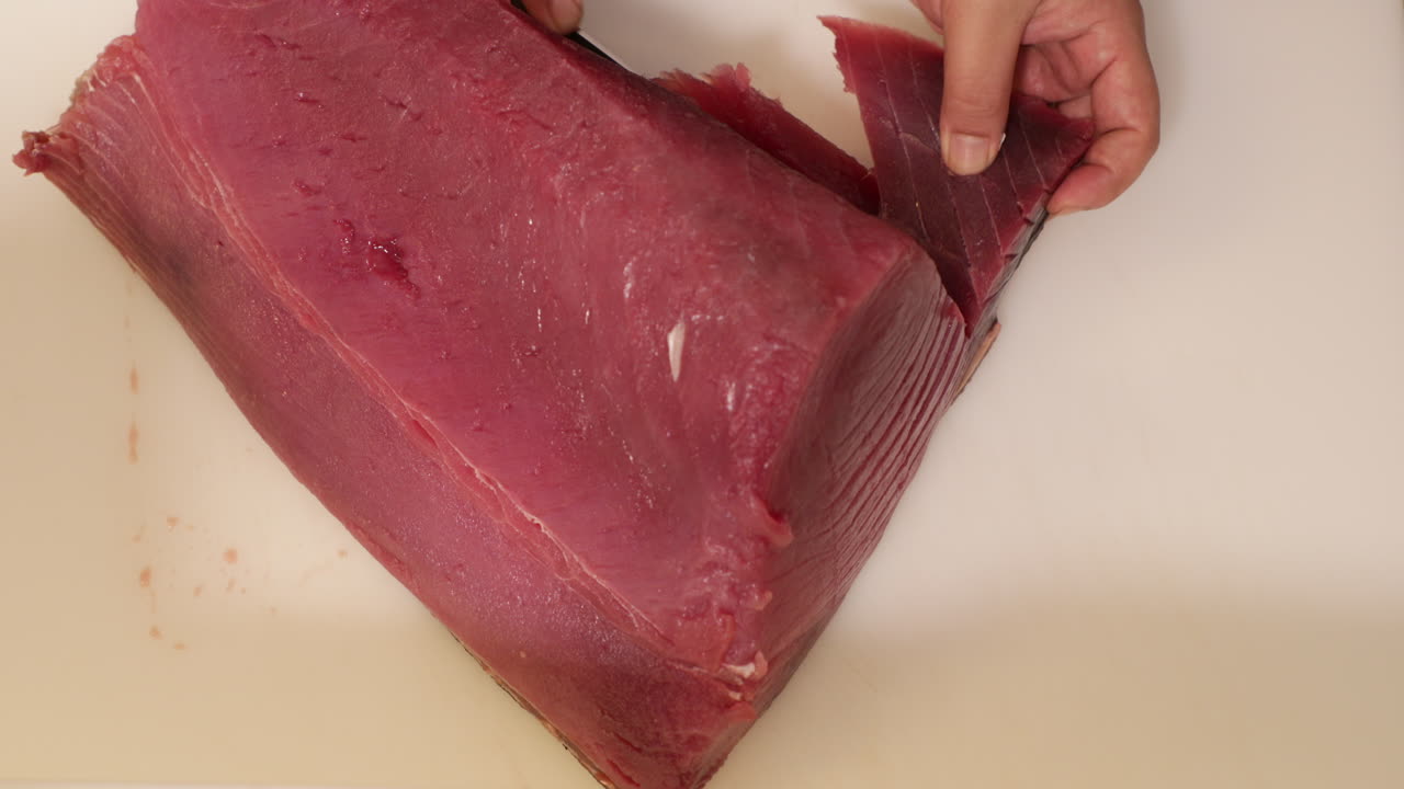 rebanar carne de atún fresco para una receta de sushi - toma de cámara lenta