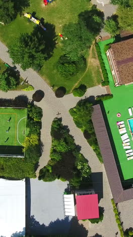 countryside spa resort complex with diverse areas for rest. swimming-pools, pond, tennis court and chaise-longues zone for comfortable time-spending. aerial view. vertical video