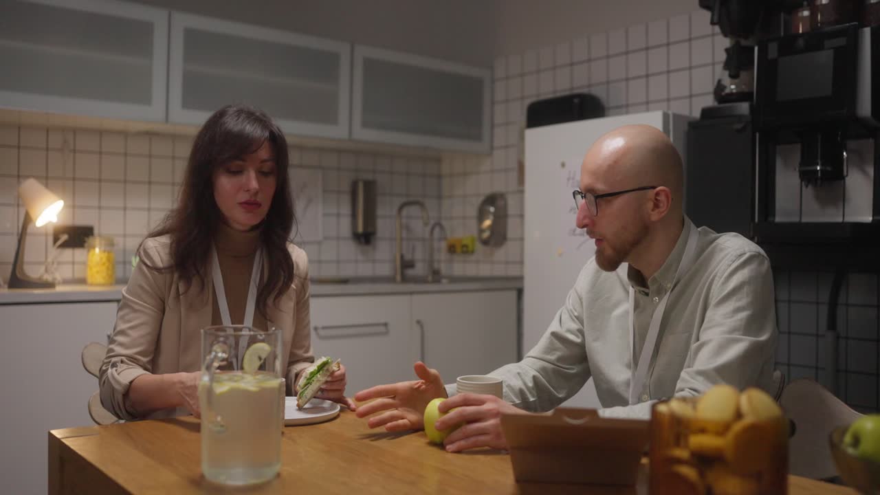 Two Colleagues Having Lunch in Office Kitchen