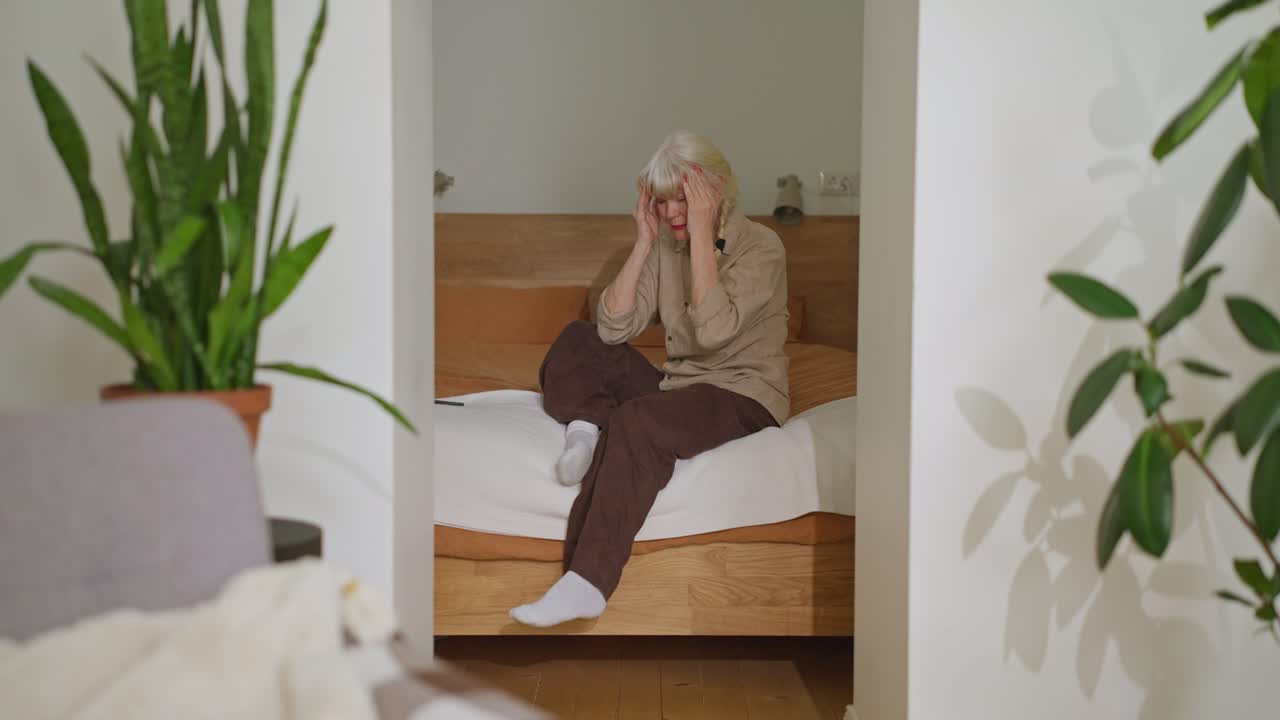 A senior woman is sitting in a room