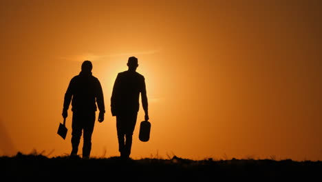 two men walking away at sunset