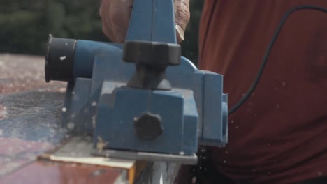 electric planing pine wood plank on boat roof slow motion