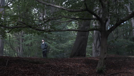 casual adult male walking towards ridge path in forest