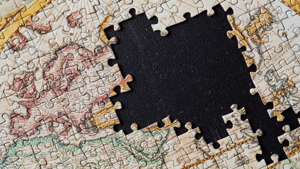 Unfinished global puzzle closeup. Antique styled map missing section on black