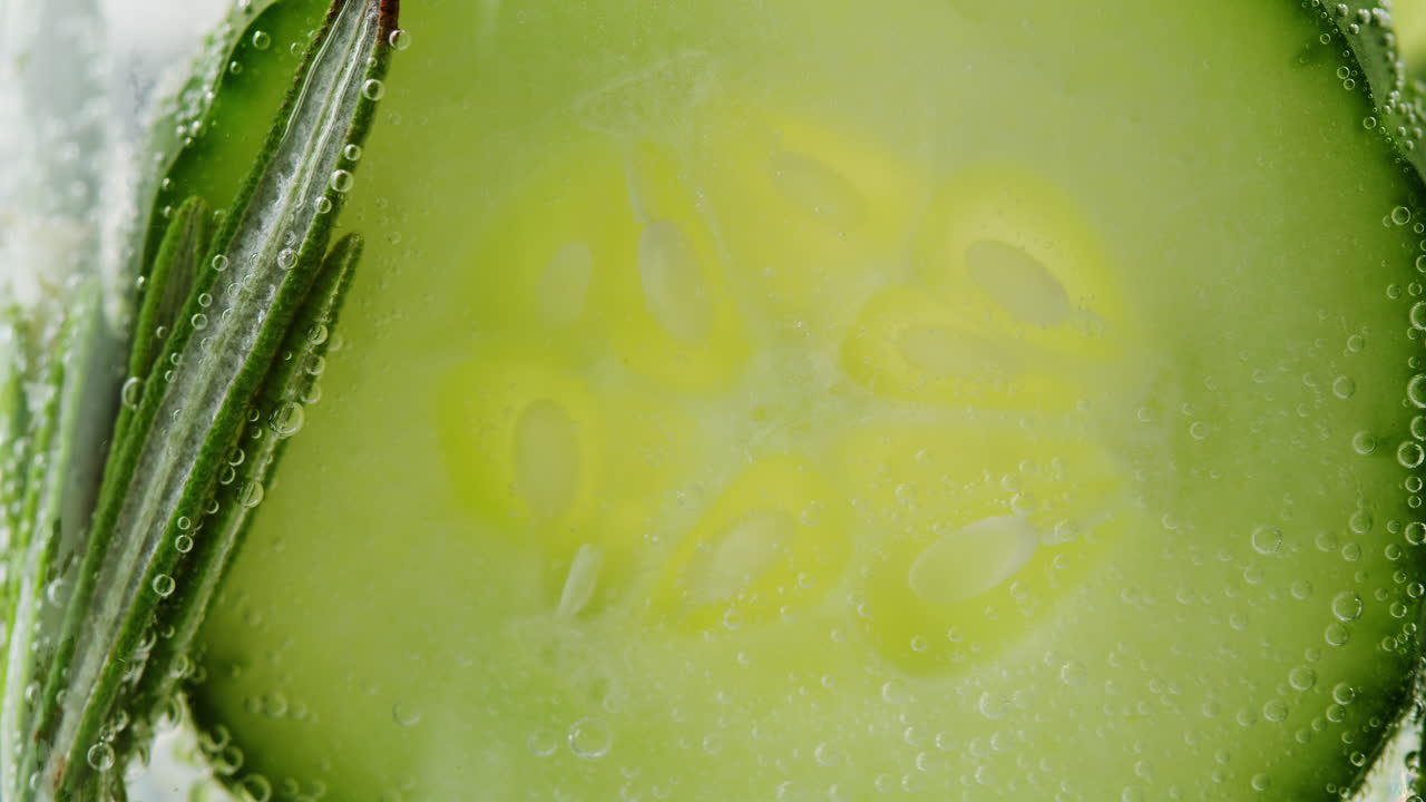 Cucumber Slice in Water with Bubbles and Rosemary