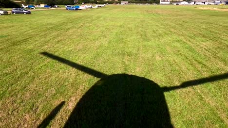 Aerial-view-of-a-helicopter-shadow-as-the-helicopter-takes-off-from-Stapleford,-UK