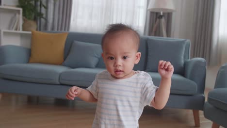 baby boy learning to walk at home