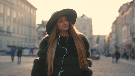 young girl going the city and listening to music on the phone