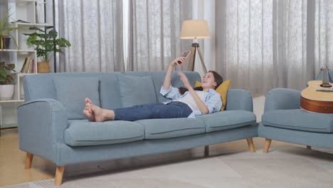 teenage girl relaxing on couch with phone