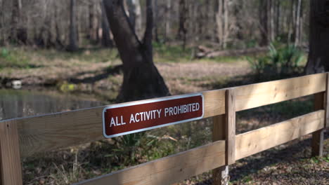 sign on a fenced warning visitors that all activities are prohibited in the fragile ecosystem of the park