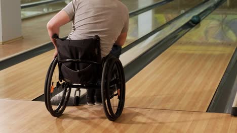 two young disabled men in wheelchairs playing bowling in the club