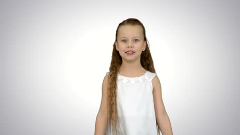 una niña linda cantando una canción y bailando sobre un fondo blanco