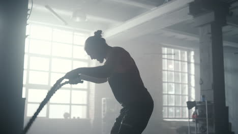 man doing fitness workout with battle ropes. guy performing sport exercise