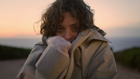 Closeup-smiling-girl-pose-in-cold-evening-weather.-Relaxed-traveler-adjust-coat