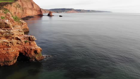 idyllic ladram bay, famous for its stunning clear water and dramatic cliffside, captured from a breathtaking aerial view