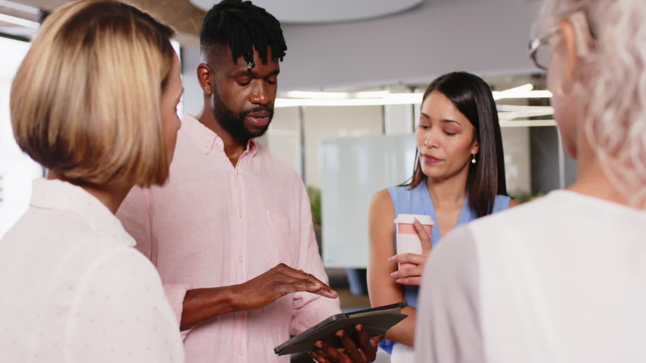 Discussing project details, diverse team collaborating in modern office environment