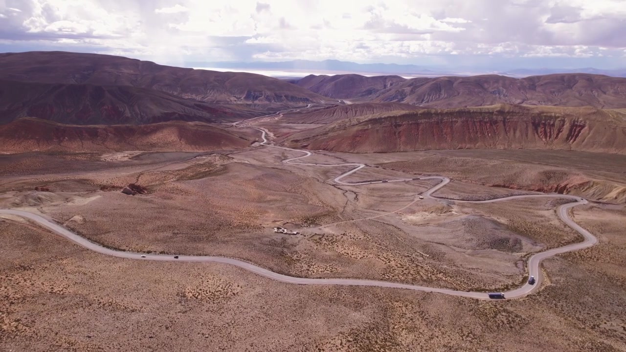 4K drone aerial view of Cuesta de Lipán, Jujuy, Argentina. Spectacular winding mountain road climbing through the Andes with dramatic curves, rugged landscapes and breathtaking high altitude scenery.