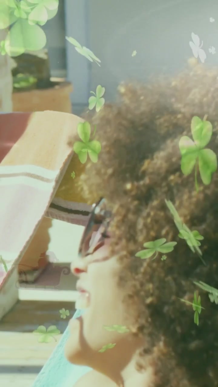 Video verticale: Telecamera che fa una panoramica ravvicinata, donna che si rilassa e parla, con trifogli che fluttuano sui capelli e annunci pubblicitari.