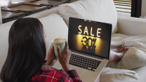 Biracial-woman-using-laptop-at-home-for-online-shopping,-slow-motion