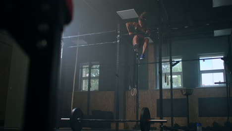 Atleta-Femenina-Balanceándose-En-La-Barra-De-Dominadas.-Mujeres-Fuertes-Haciendo-Dominadas-En-Barras-De-Gimnasia-En-El-Gimnasio.-El-Atleta-Profesional-Hace-Ejercicios-De-Fuerza-De-Dominadas-Y-Ejercicios-Cruzados-Y-Rutina-De-Ejercicios-Diaria.