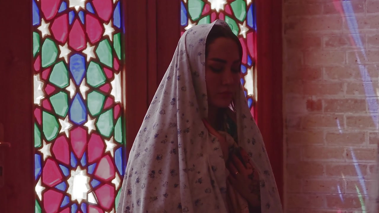 Two Women in Traditional Headscarves Standing by Stained Glass Window