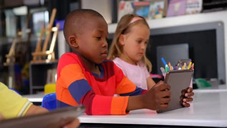 front view of african american schoolboy using digital tablet in the classroom 4k