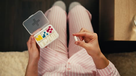 woman taking medicine in pajamas