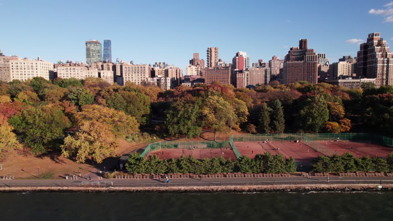 NYC's Riverside Park, tennis courts and pedestrian trail with UWS buildings in background.