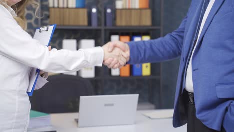 empleada y gerente estrechándose la mano.