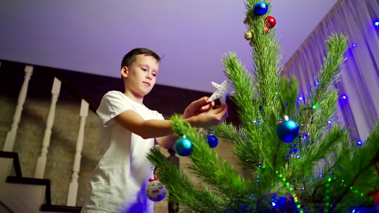 Boy decorates Christmas tree. Happy children decorating the Christmas tree
