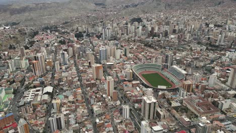 aerial drone above stadium hernando siles in la paz, bolivia, populated city in south america, high altitude neighborhood below andean cordillera mountain rainge