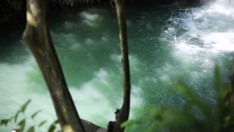 Slow-Motion-shot-of-a-man-doing-a-back-flip-into-the-swimming-hole-at-Aling-Aling-Waterfall-in-Bali,-Indonesia